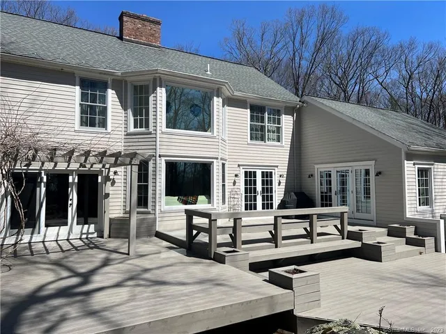 a view of a patio with couches table and chairs with wooden floor and fence