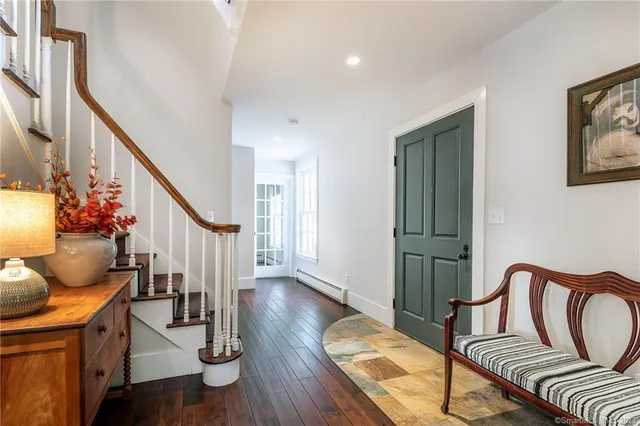 a living room with furniture stairs and a potted plant