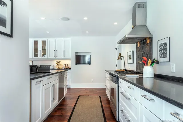 a large kitchen with stainless steel appliances a stove and a sink
