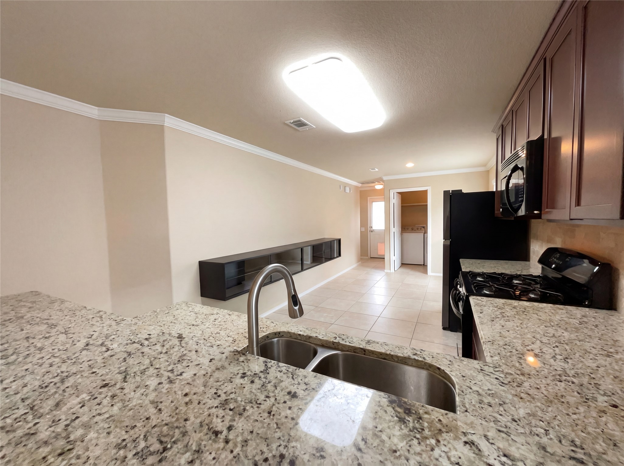 7208 Outfitter Drive Austin, TX 78744 - Photo 16 of 34 a kitchen with granite countertop a stove a sink and a refrigerator