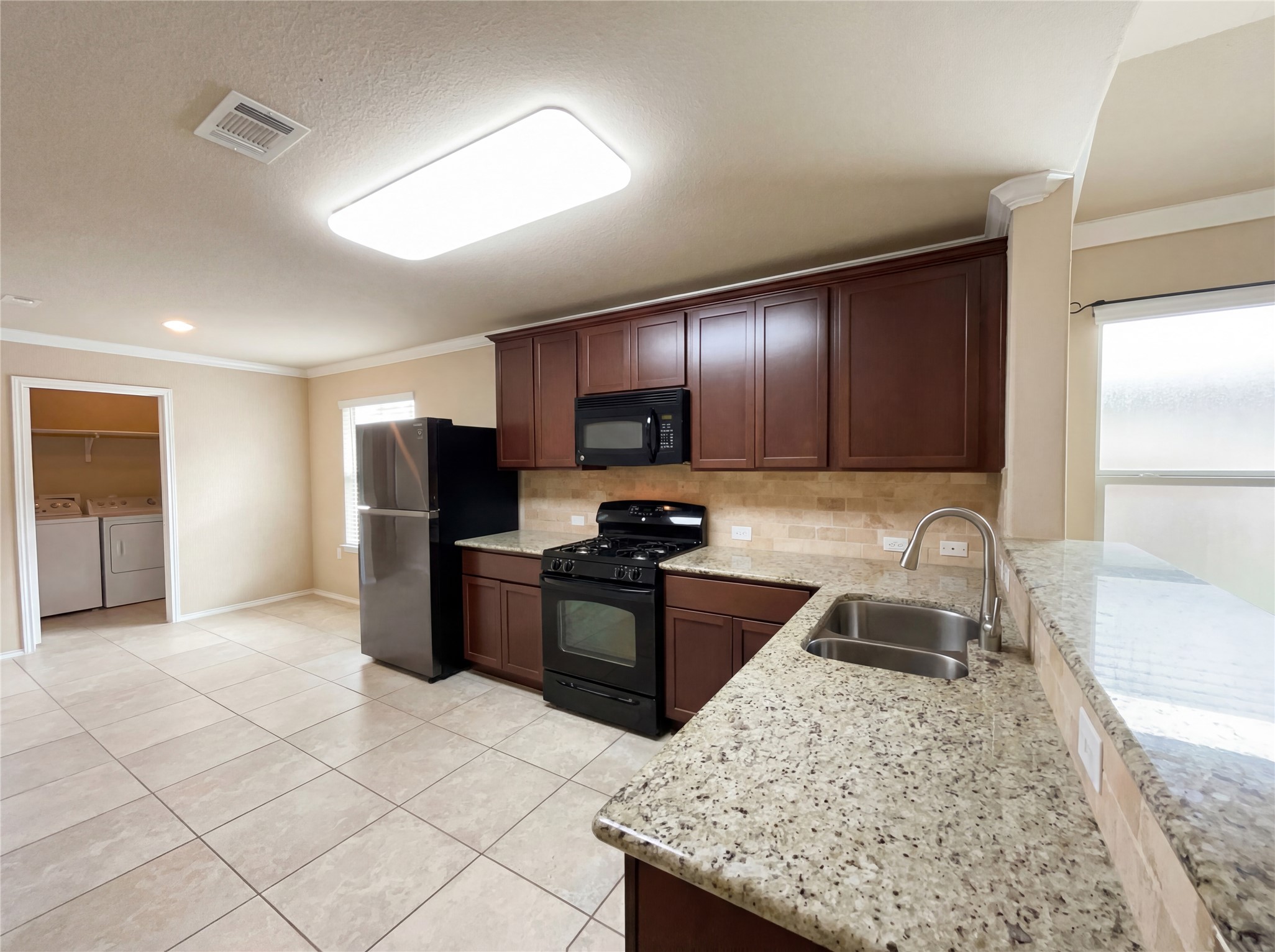 7208 Outfitter Drive Austin, TX 78744 - Photo 17 of 34 a kitchen with stainless steel appliances granite countertop a sink stove and refrigerator