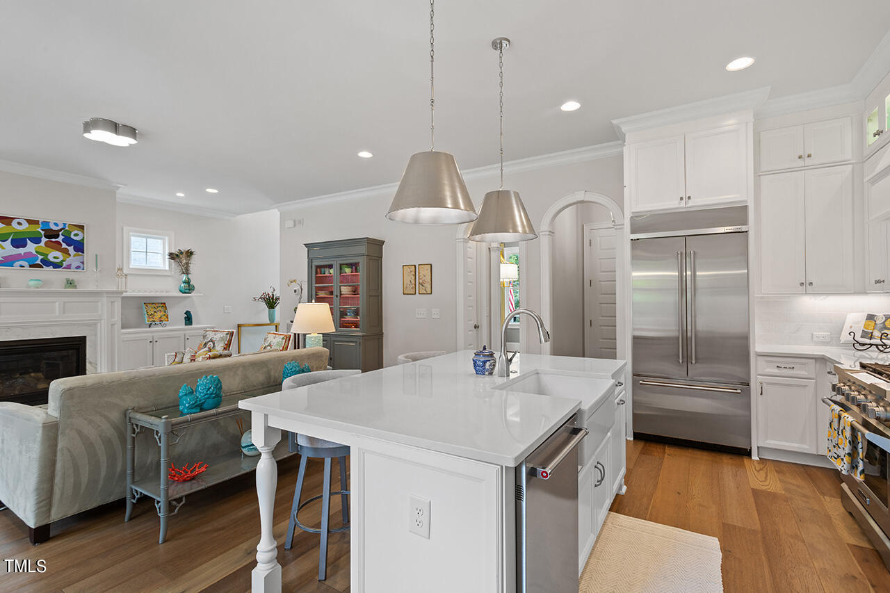 913 Canterbury Road Raleigh, NC 27607 - Photo 11 of 36 a kitchen with kitchen island a stove a chandelier and a refrigerator