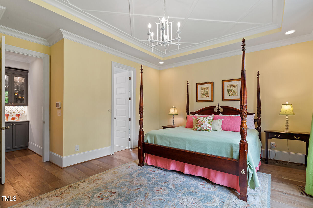 913 Canterbury Road Raleigh, NC 27607 - Photo 16 of 36 a bedroom with a bed and wooden floor