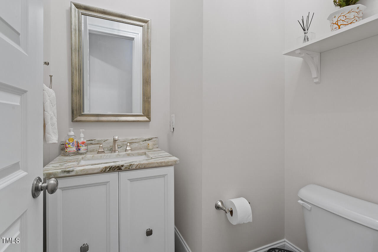 913 Canterbury Road Raleigh, NC 27607 - Photo 20 of 36 a bathroom with a toilet sink vanity and mirror