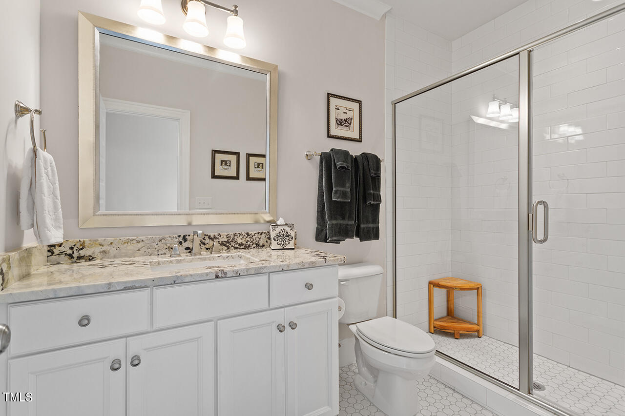 913 Canterbury Road Raleigh, NC 27607 - Photo 28 of 36 a bathroom with a sink toilet vanity and shower