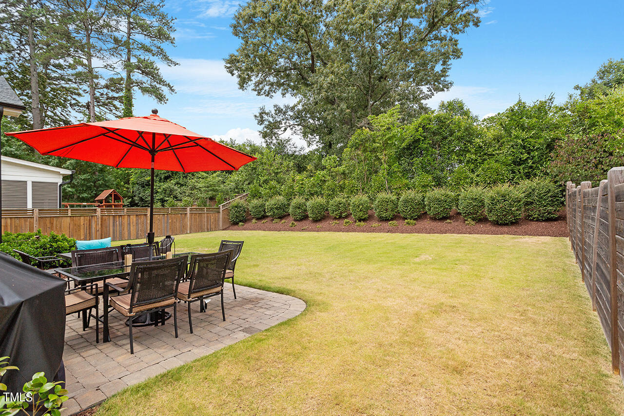 913 Canterbury Road Raleigh, NC 27607 - Photo 36 of 36 a view of a swimming pool with table and chairs under an umbrella