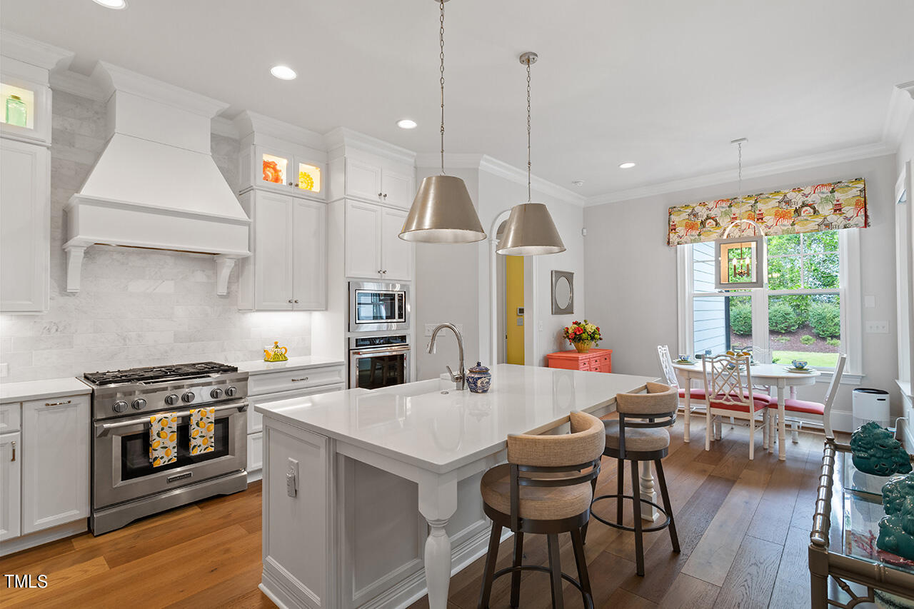 913 Canterbury Road Raleigh, NC 27607 - Photo 9 of 36 a kitchen with a table chairs stove and wooden floor