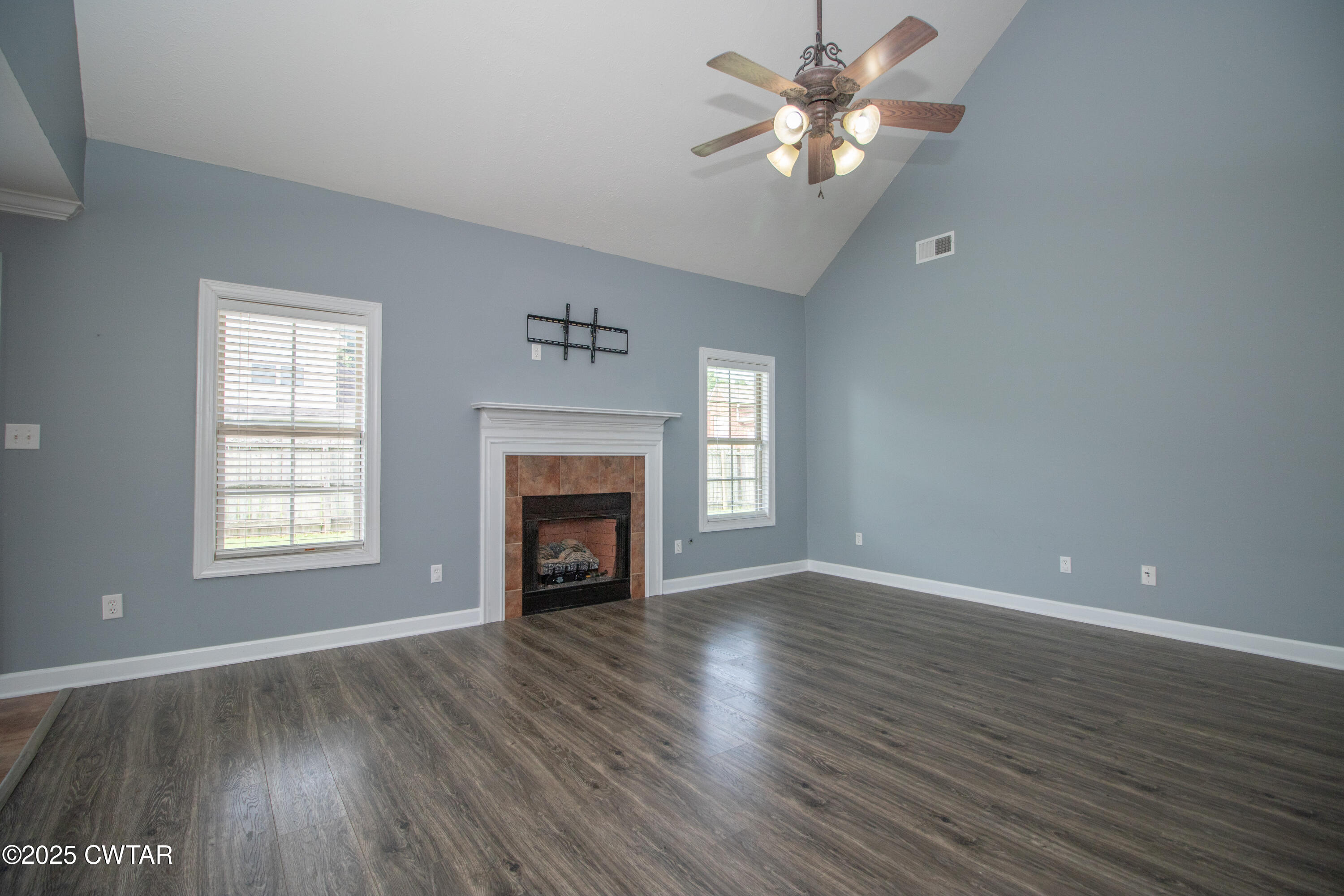 241 Stone Ridge Cove Medina, TN 38355 - Photo 15 of 59 an empty room with wooden floor a chandelier fan and windows