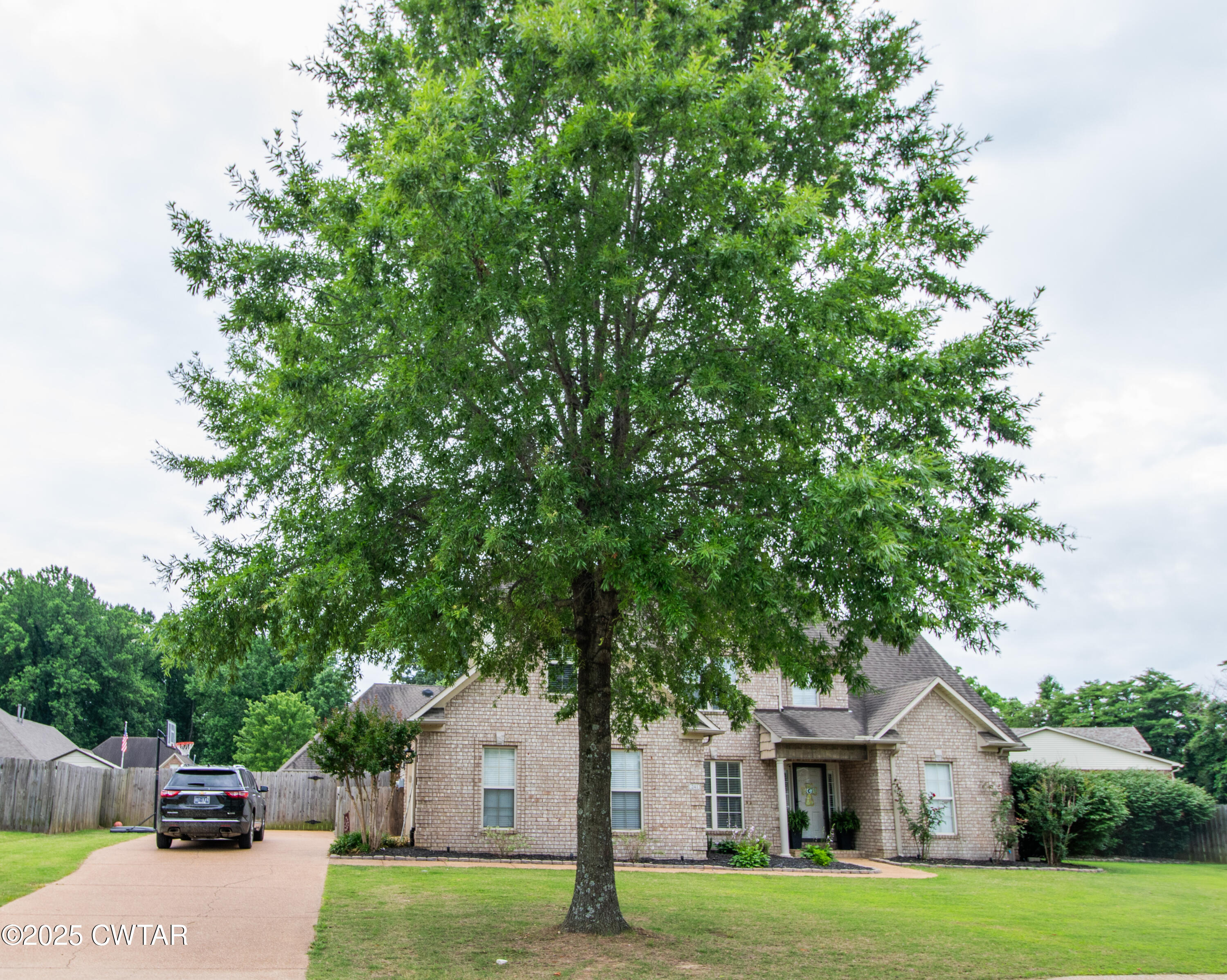 241 Stone Ridge Cove Medina, TN 38355 - Photo 6 of 59 a front view of a house with a garden and trees