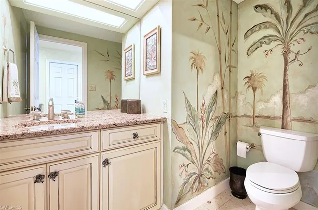 a bathroom with a granite countertop sink a toilet and a mirror