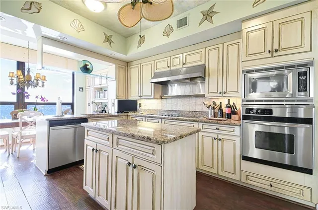a kitchen with stainless steel appliances granite countertop a stove and cabinets