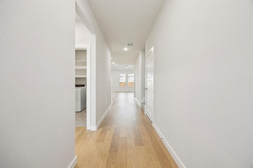 5803 Rushing River Way McKinney, TX 75071 - Photo 32 of 34 a view of a hallway with wooden floor