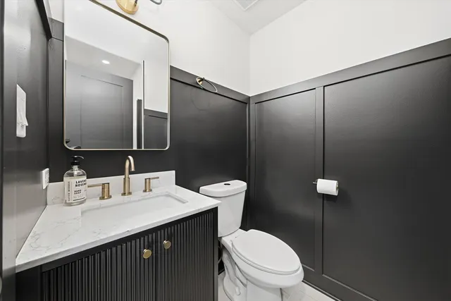 a bathroom with a sink a toilet a mirror and shower