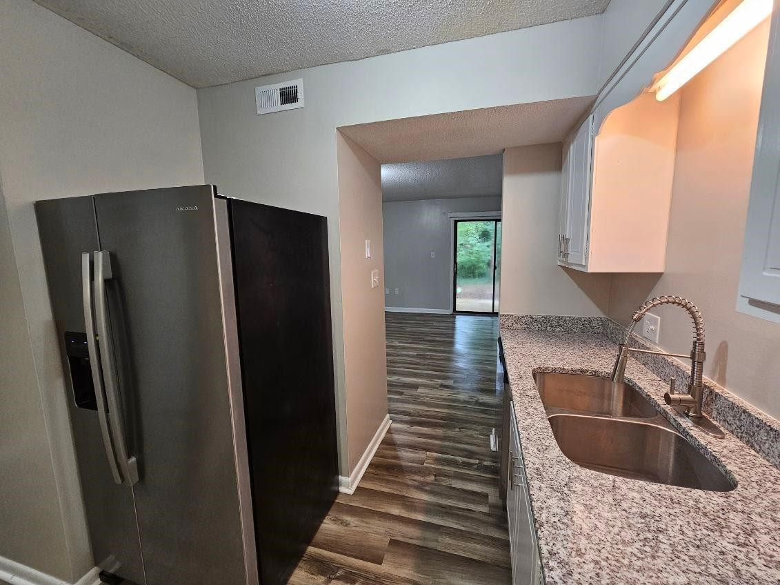 5052 Flint Ridge Place, Unit 5052 Raleigh, NC 27609 - Photo 11 of 67 a kitchen with granite countertop a refrigerator and a sink