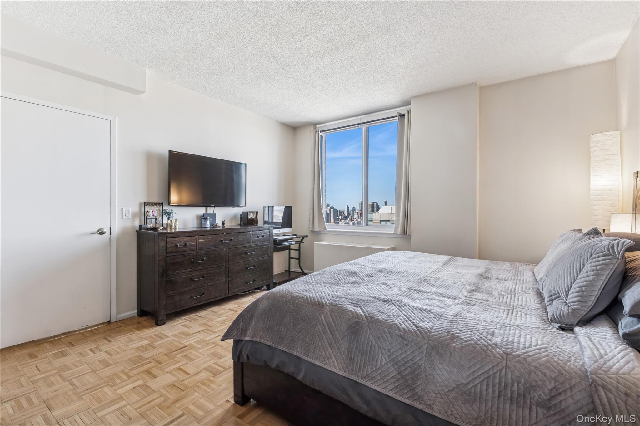 4-74 48th Avenue, Unit PH4D Queens, NY 11109 - Photo 11 of 28 a bedroom with a bed and a flat screen tv