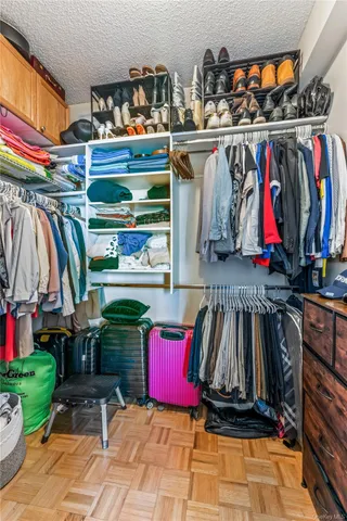 a view of walk in closet with clothes and shoes