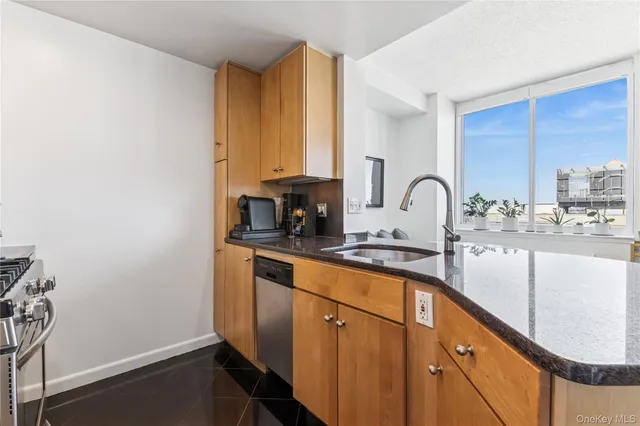 a kitchen with stainless steel appliances granite countertop a sink a stove a microwave a sink and cabinets