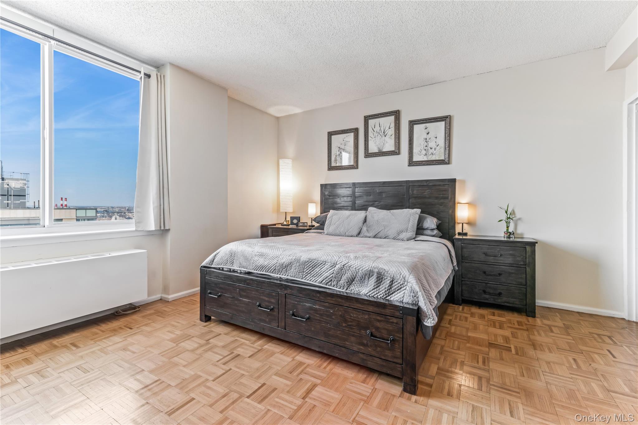 4-74 48th Avenue, Unit PH4D Queens, NY 11109 - Photo 9 of 28 a bedroom with a bed and a window