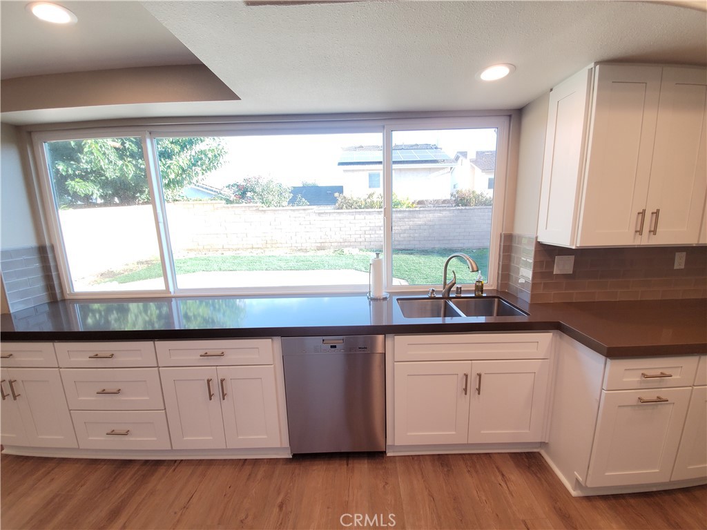 a kitchen with a large window sink and cabinets