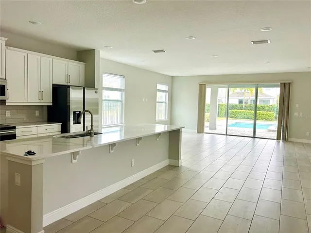 a view of a kitchen with kitchen island a sink wooden floor and glass window