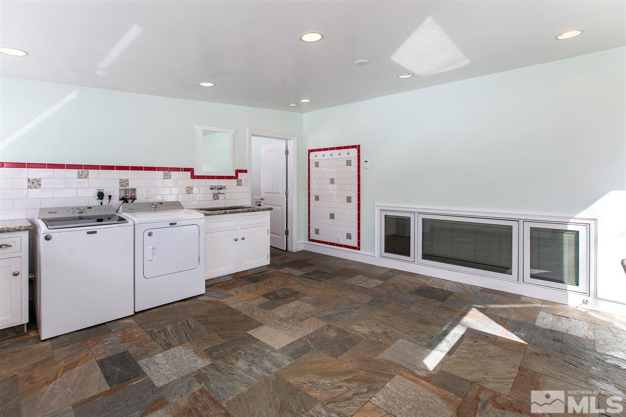 2145 Greentree Lane Reno, NV 89511 - Photo 12 of 25 a large white kitchen with a sink and dishwasher with a fireplace