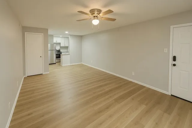 wooden floor in an empty room with a kitchen