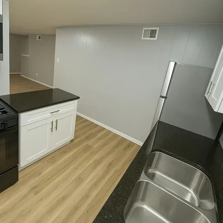 a bathroom with a granite countertop toilet a sink and a mirror