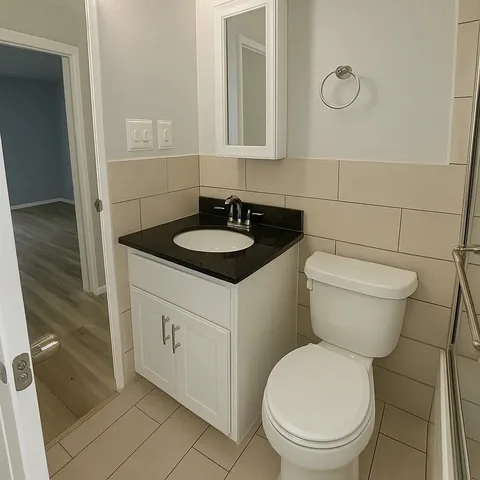 a bathroom with a sink a toilet and shower