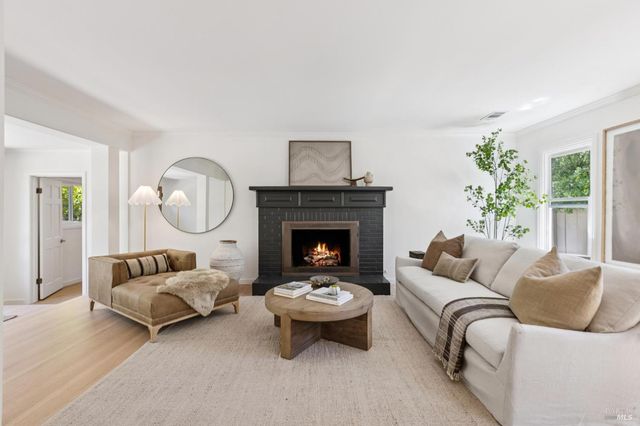 a living room with furniture a fireplace and a large window