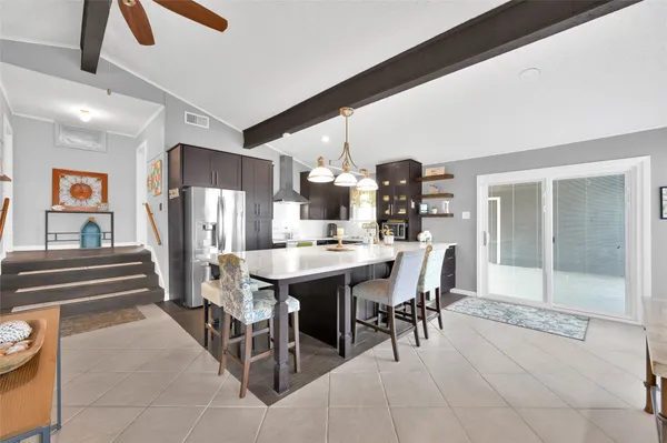 a dining room with wooden floor a chandelier a wooden table and chairs
