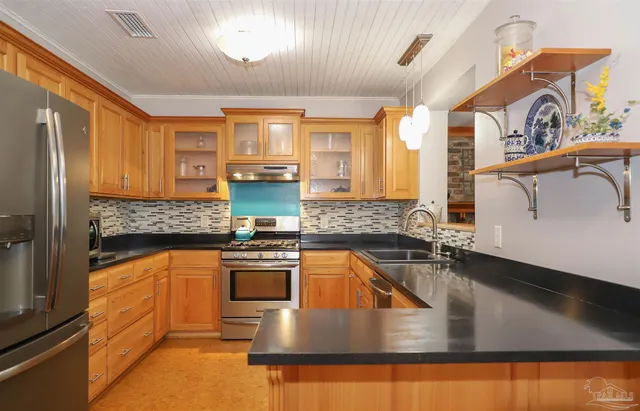 a kitchen with stainless steel appliances granite countertop a sink stove and refrigerator