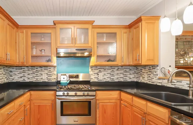 a kitchen with stainless steel appliances a stove sink and cabinets