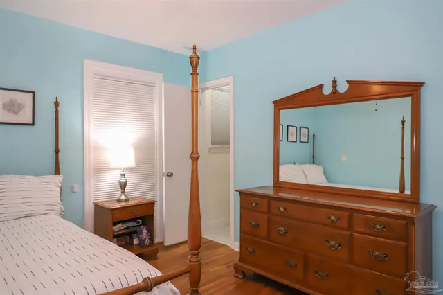 a bedroom with a bed and a mirror on dresser
