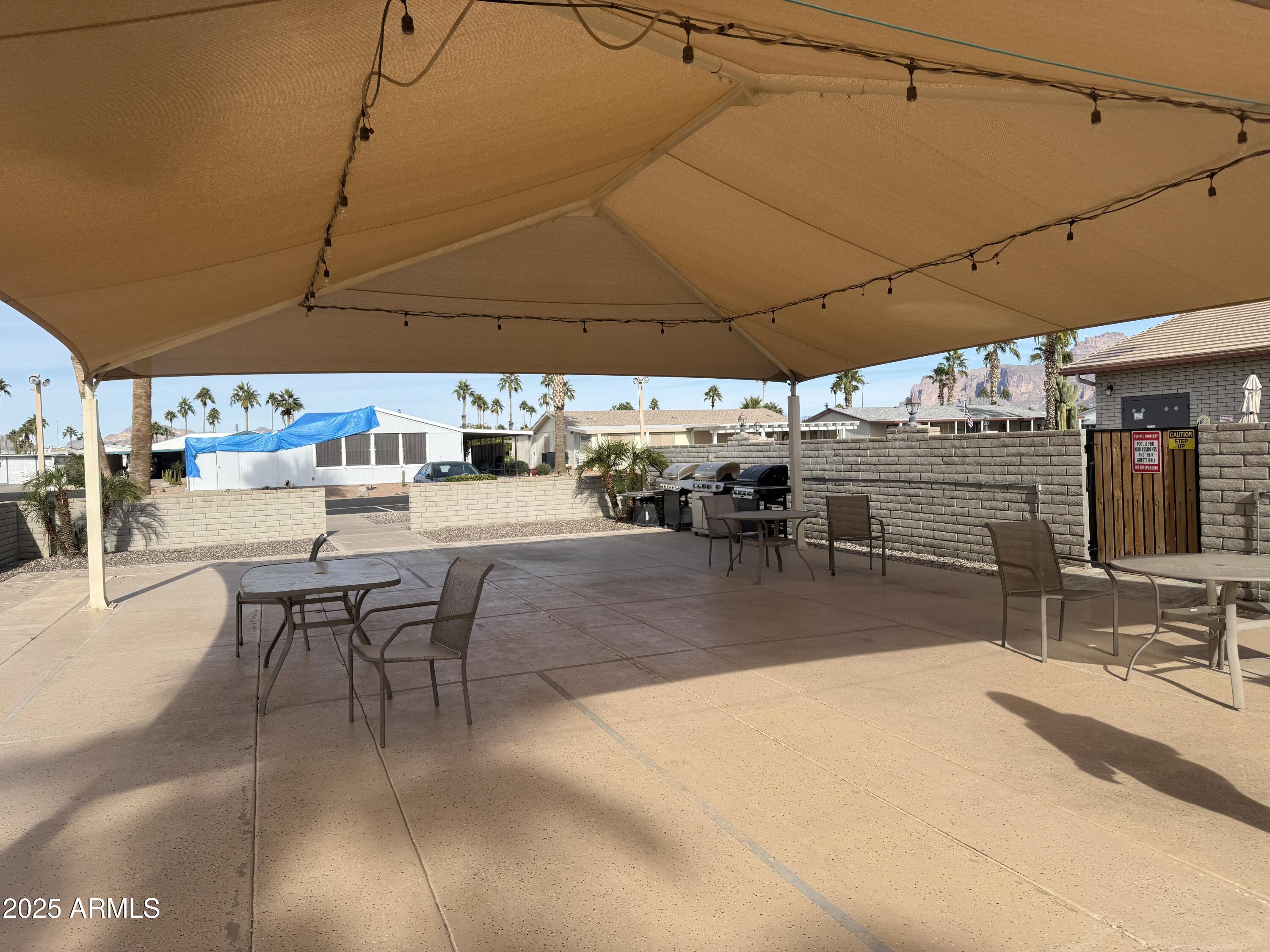3700 South Tomahawk Road, Unit 22 Apache Junction, AZ 85119 - Photo 30 of 30 a view of a patio with table and chairs under an umbrella