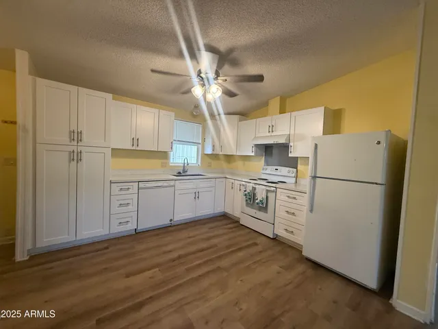 a kitchen with white cabinets and white appliances