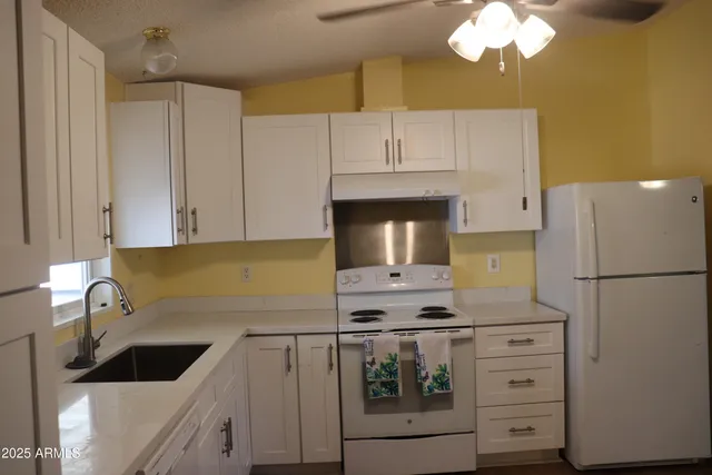 a kitchen with cabinets appliances and a sink