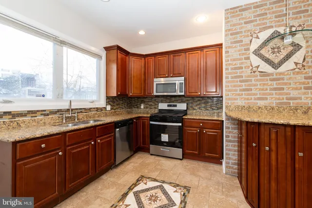 a kitchen with stainless steel appliances granite countertop a stove sink and cabinets