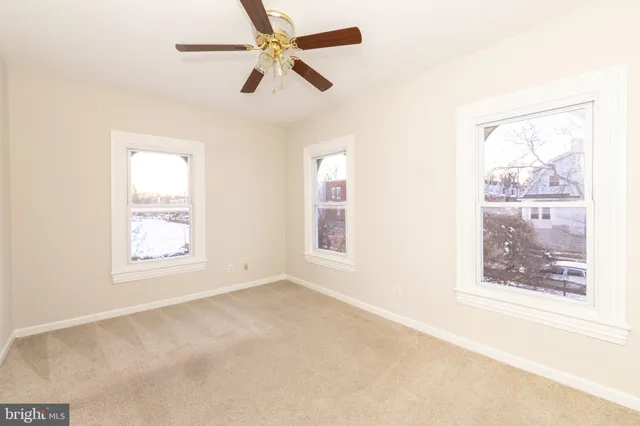 an empty room with a window and a fan