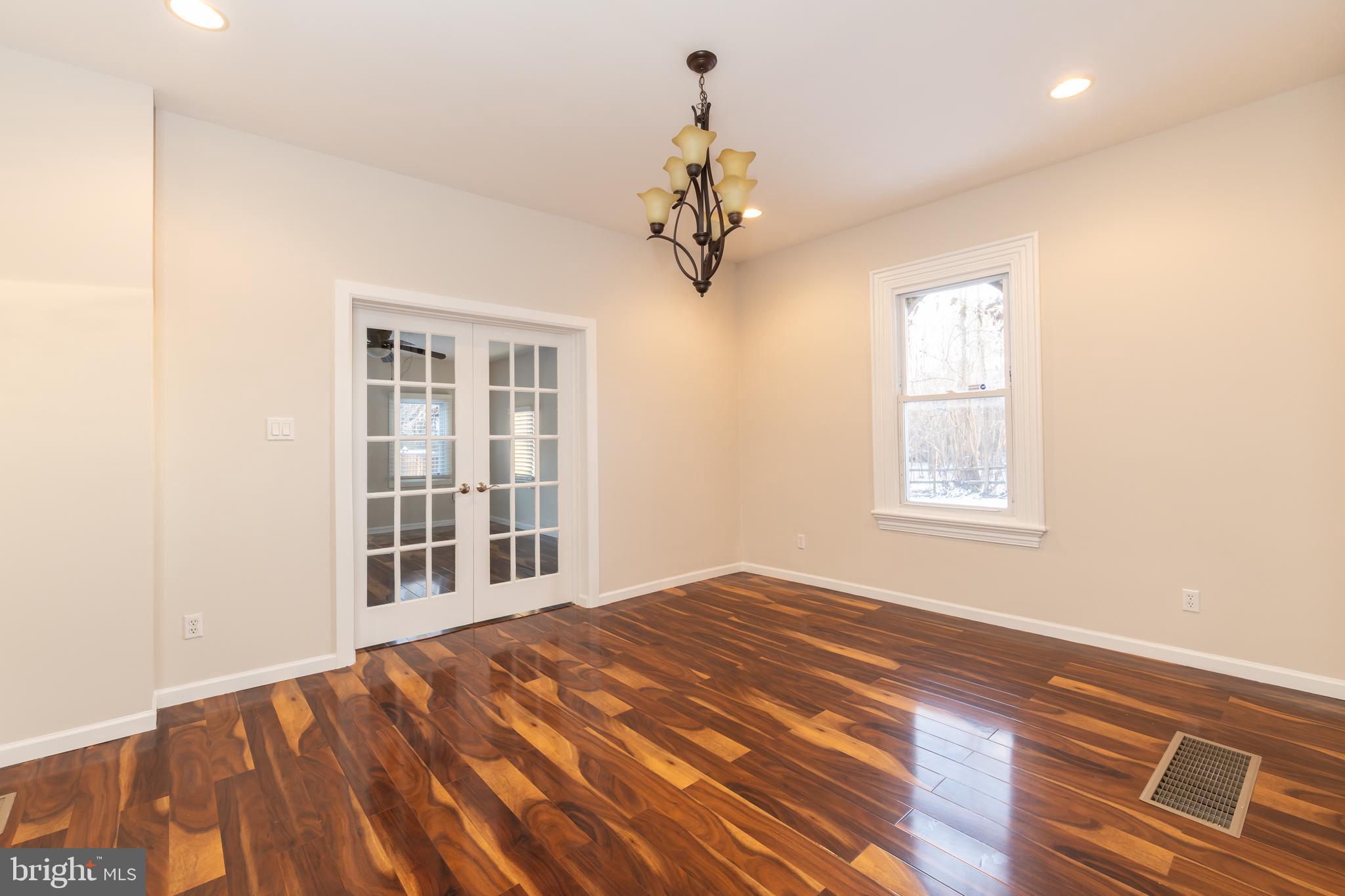 724 East Locust Avenue Philadelphia, PA 19144 - Photo 10 of 34 an empty room with wooden floor chandelier and windows