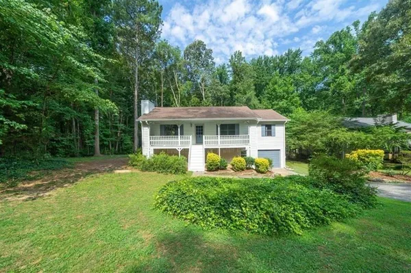 a view of a house with a yard and sitting area