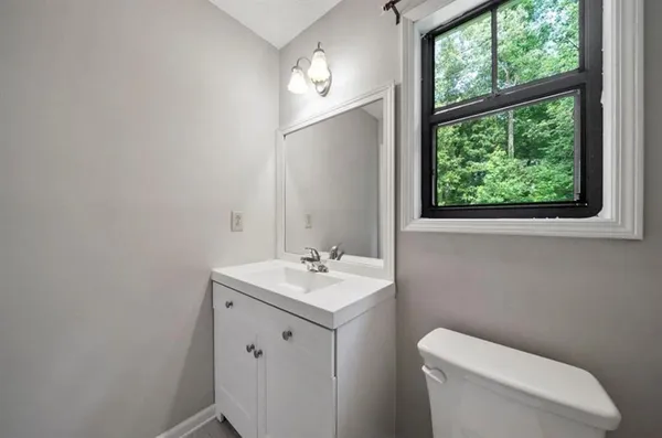 a bathroom with a toilet sink and mirror