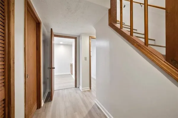 a view of a hallway with wooden floor and staircase
