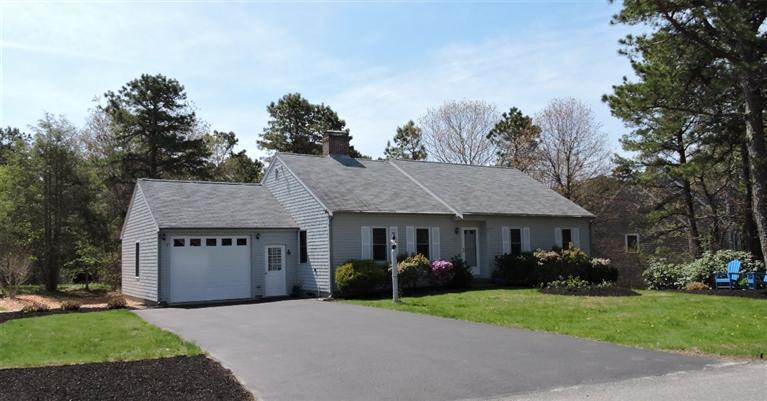 130 Surf Drive Mashpee, MA 02649 - Photo 1 of 29 a front view of a house with a yard and trees