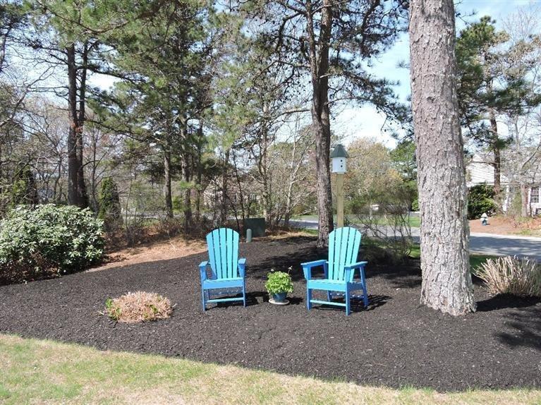 130 Surf Drive Mashpee, MA 02649 - Photo 3 of 29 a view of a park with large trees and outdoor seating