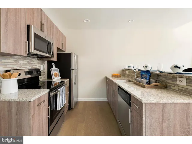a kitchen with stainless steel appliances granite countertop a sink stove and microwave