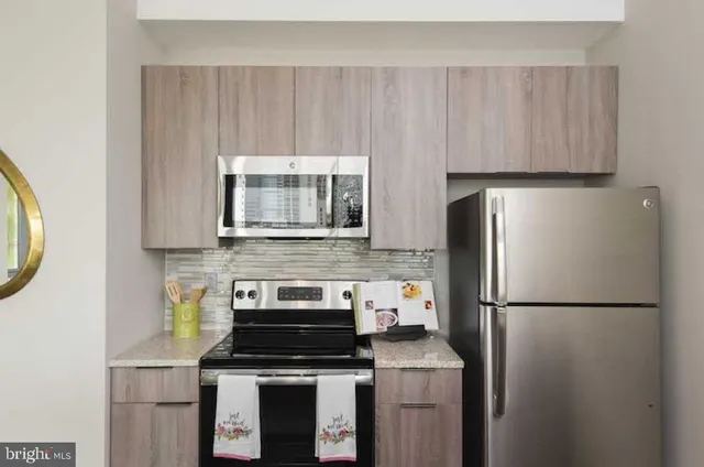 a kitchen with a stove a refrigerator and a microwave
