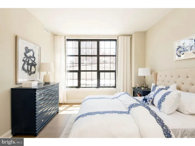 a bedroom with a bed and a large window