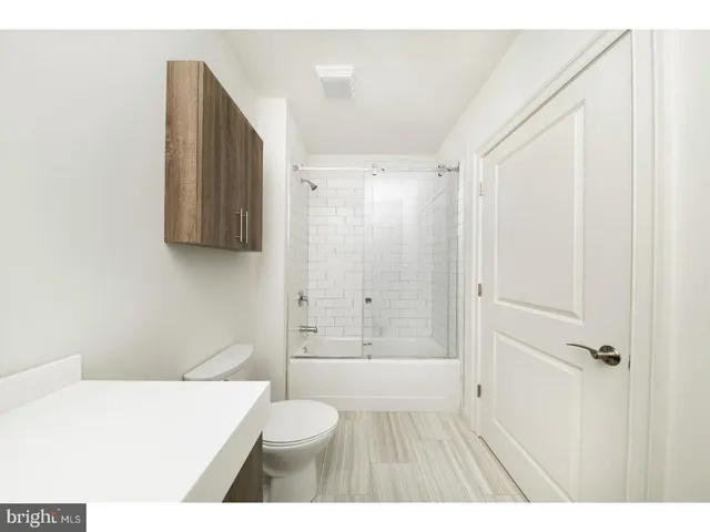 a bathroom with a shower a toilet and a sink