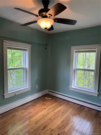 a view of an empty room with wooden floor