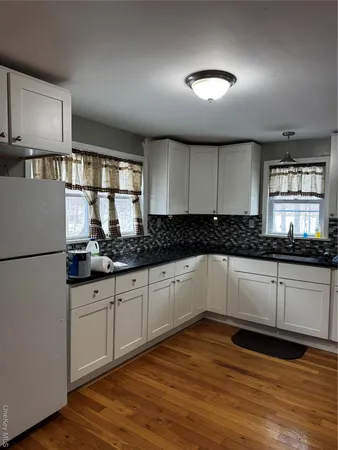 a kitchen with granite countertop white cabinets and white appliances